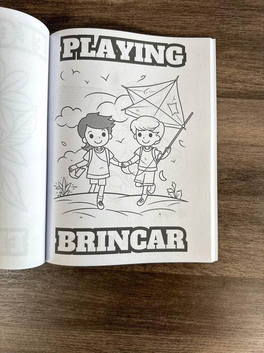 Open book with black and white illustration of two children playing with a kite, on a wooden surface. How To Cook Portuguese Stuff coloring book


